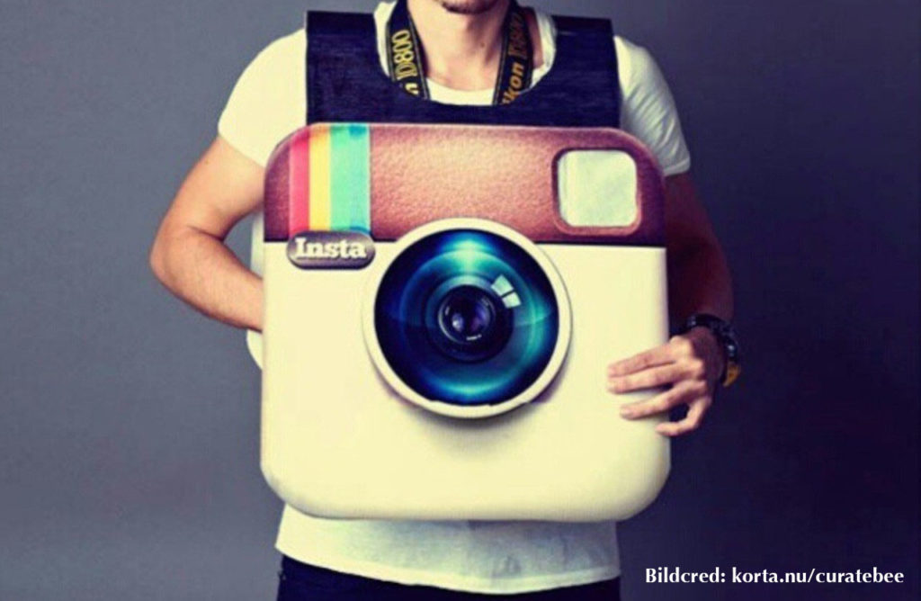 Man som håller i Instagram-logo